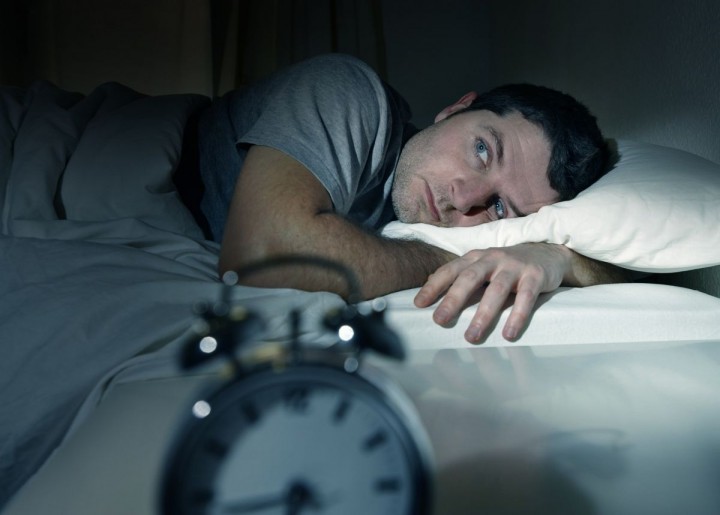 man in bed with eyes opened suffering insomnia sleep disorder